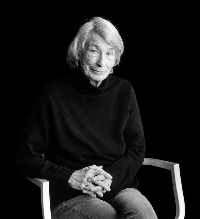 Black and white portrait photo of seated Mary Oliver.