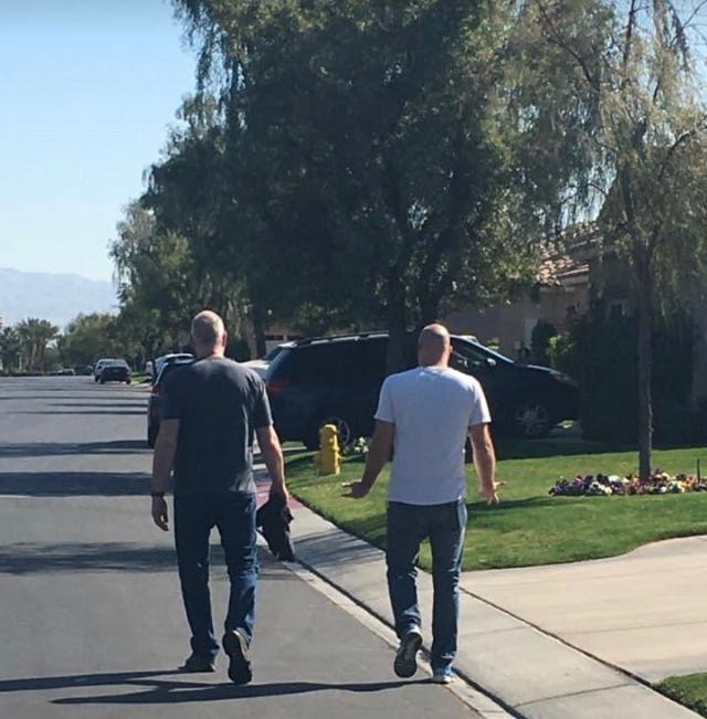 Myself and my brother david walking away from the camera next to each other on a quiet street.