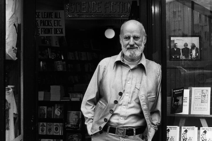 Black and white photo of Lawrence Ferlinghetti in the doorway of his bookshop.
