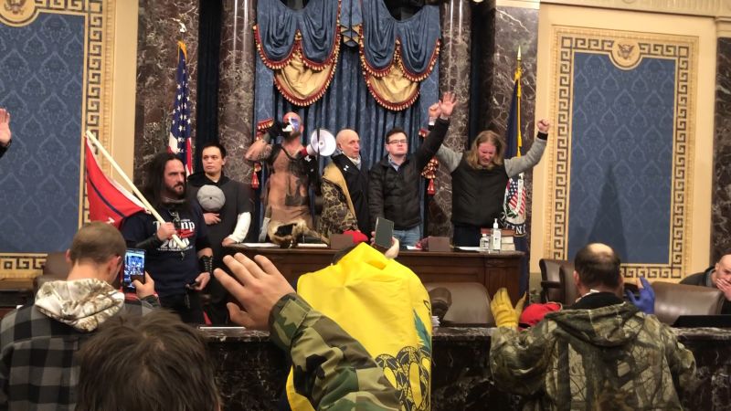 January 6, 2021 Capitol rioters standing on the podium of the us House of Representatives.